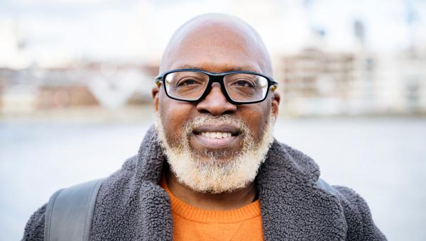 Homme souriant devant une berge de rivière