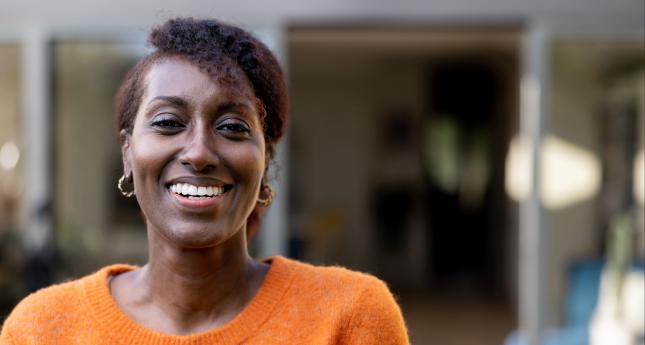 Une femme souriante devant sa boutique