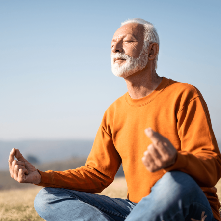 Homme senior en assise sur une plage