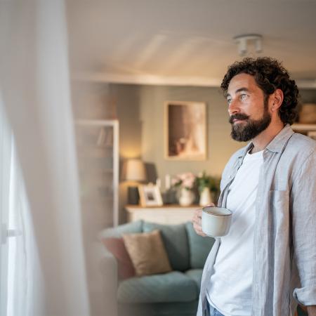 Homme 45 ans se relaxant devant une fenêtre ouverte