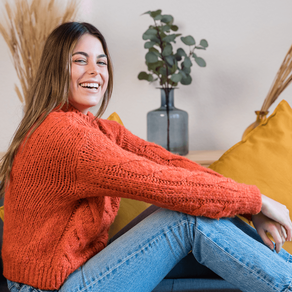 Jeune fille souriante assise sur un canape