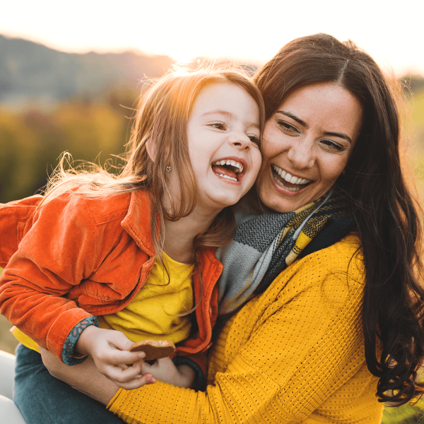 Une mère et sa fille s'amusant dans le soleil couchant