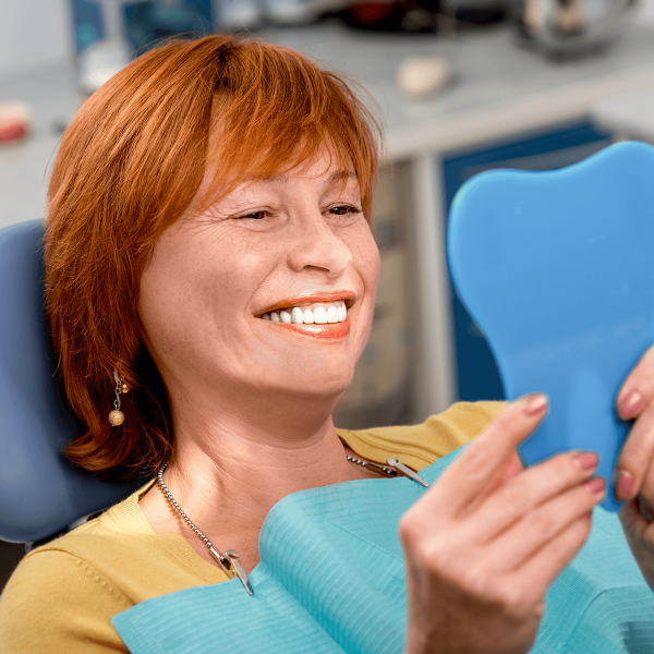 Femme se regardant dans un miroir chez le dentiste