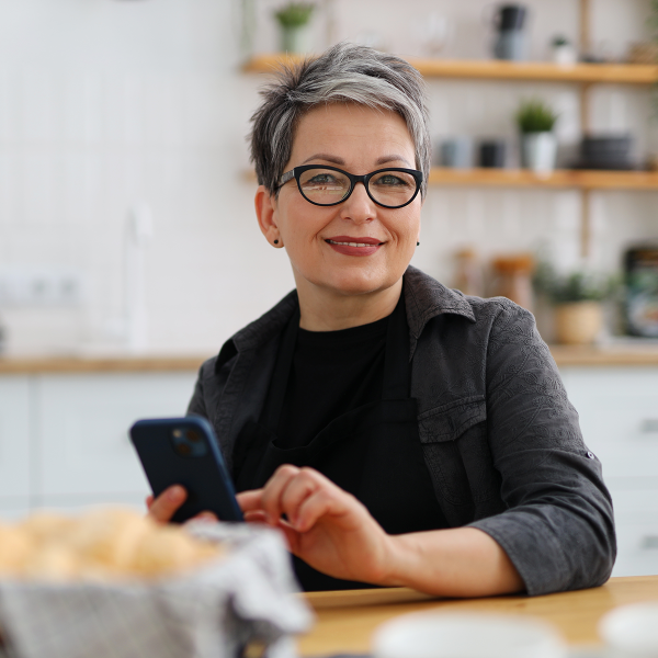 Personne consultant son mobile dans une cuisine